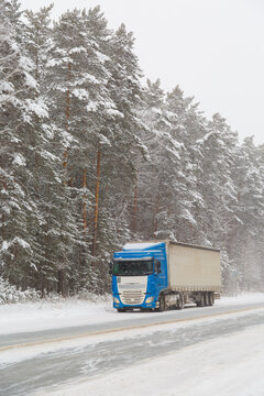 Truck driving near snowy trees