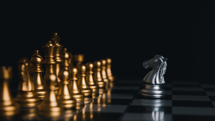 The silver horse in the chess board game is facing another golde team. Competition,Strategic ideas...