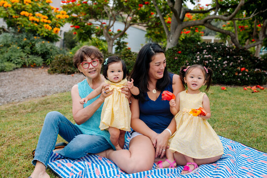 Three generations of asian females outdoors on blanket