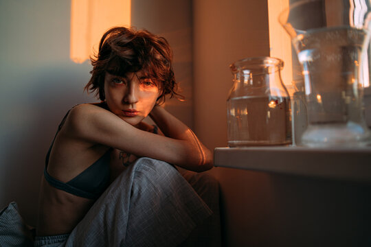 young woman by the window in the sunset light