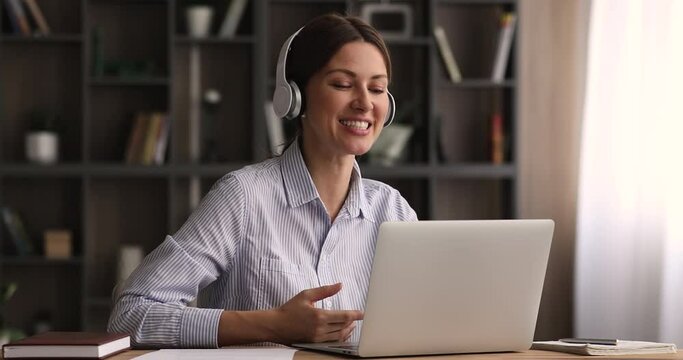 Woman sit at desk wear headphones talk to client give helpful information provide professional services of counselling remotely using video conference application and laptop. Video call event concept