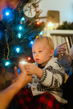 Kid looking at a candle during Christmas