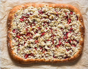 Strawberry yeast pie with crumble on a light background, top view