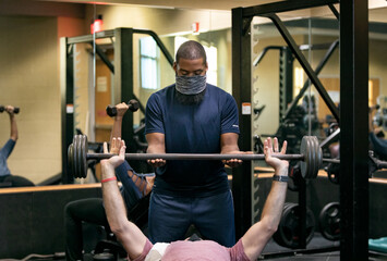 Gym: Friend Spots Man Training With Barbell