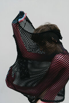 slim woman with bodypainting on her body in a fishnet