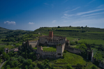 Soave castle aerial view, province of Verona, Italy. The famous medieval castle on the hill. Italian historic castles. Aerial panorama of Italy castles.