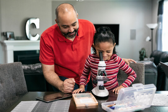 Home: Dad Helps Girl With Microscope While Homeschooling During 