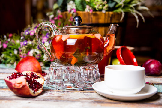red fruit tea with pomegranate and white cup on the table