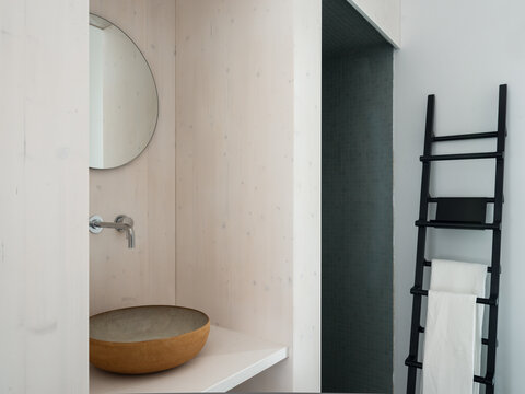 Mirror and ceramic sink in a contemporary minimalist bathroom