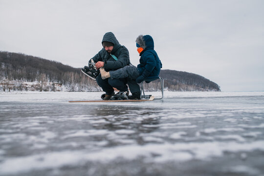 Father and son get ready for ice hockey