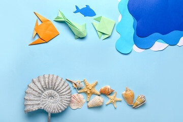 Paper fishes and sea waves with shells on color background. Ecology concept