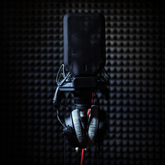 Professional studio condenser microphone in recording studio with studio headphones on a sound...