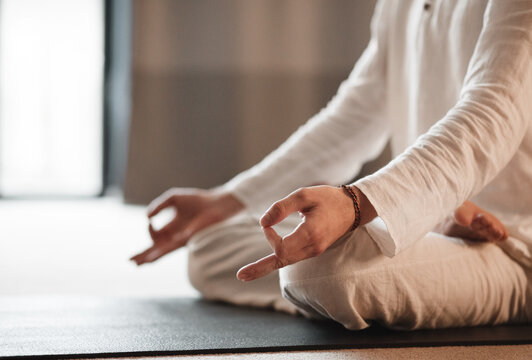 Crop man gesturing Gyan mudra and meditating