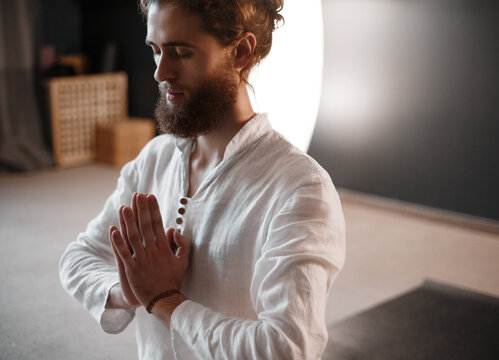 Bearded man praying during meditation