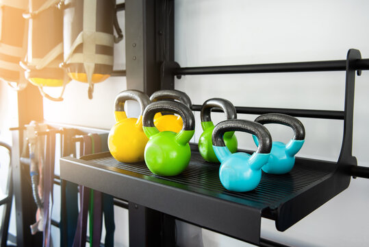 various colored dumbbells on a shelf in a gym. sports equipment