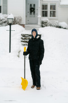 teenage boy shovelling his neighbour's pathway