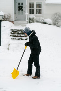 teenage boy shovelling his neighbour's pathway