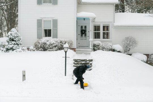 teenage boy shovelling his neighbour's pathway