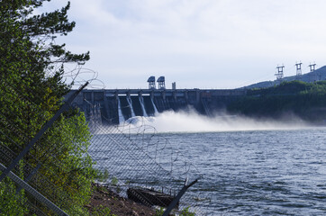 Discharge of excess water from floodgates during flooding. Hydroelectric power station behind a...