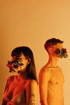 young couple in flower masks in the studio