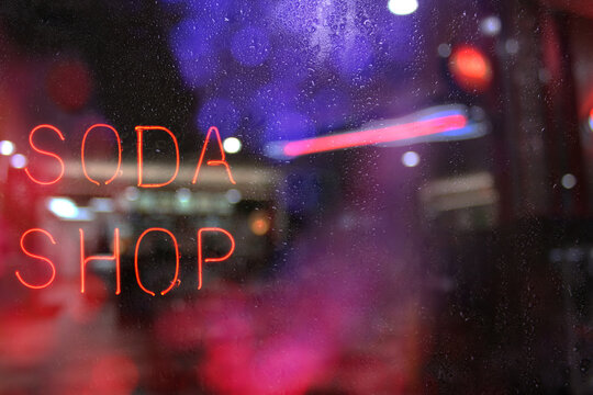 Vintage Neon Soda Shop Sign in Wet Rainy Window