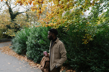 Student walking with Coffee Cup in the Park