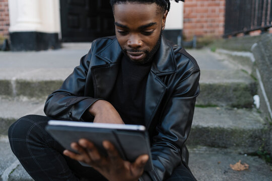 Afrom Man using Digital Tablet Outdoors