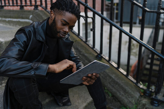 Afrom Man using Digital Tablet Outdoors