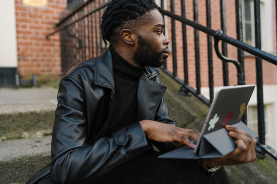 Afrom Man using Digital Tablet Outdoors