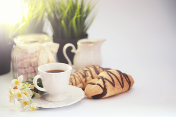 French breakfast on the table. Coffee croissant with chocolate and a decanter with cream. Fresh pastries and decaffeinated coffee.