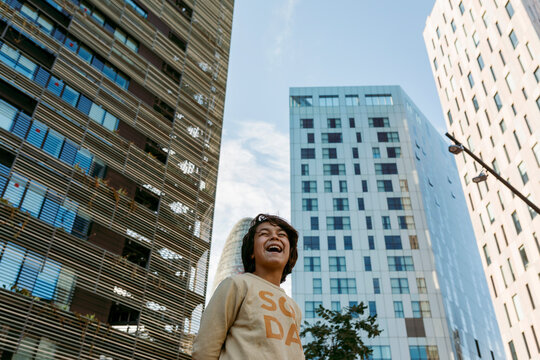 smiling pre teen boy portrait against tall buildings