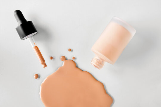 Mockup glass bottle of correction cosmetic product with pipette. Spilled Liquid foundation. Beauty branding concept