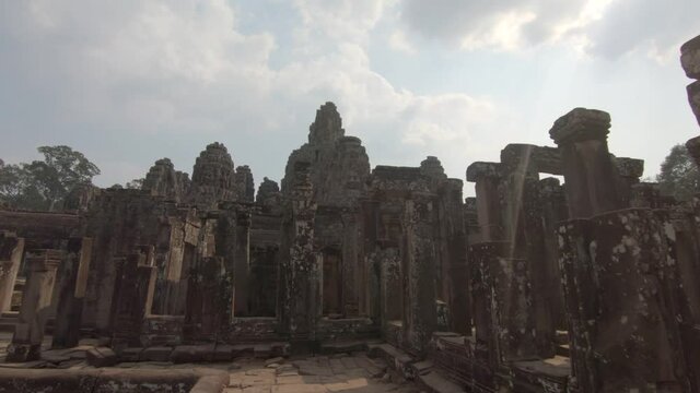 Wide landscape shot tilting up over the ancient temples of Angkor wat in Cambodia cloudy but bright daylight.