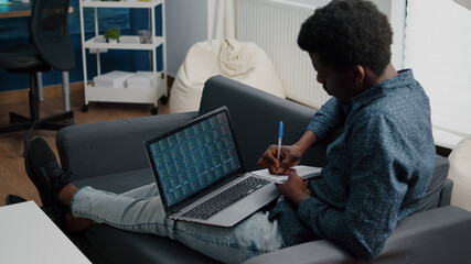 African american man analyzing crypto currency stock markets trading, checking stock ticker index, deciding to buy or sell digital coin money. Black guy watching bitcoin charts forex investment