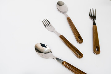 Spoon and fork with wooden handles on the white background