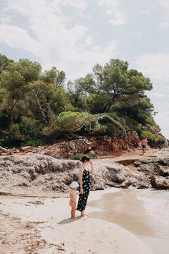 mother with toddler in swimwear looking over the ocean