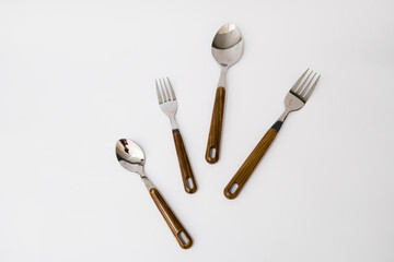 Spoon and fork with wooden handles on the white background