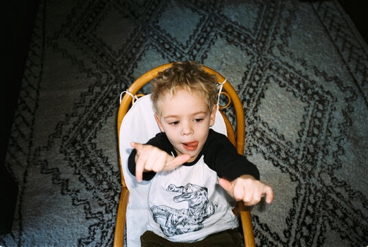 analog night shot of child sitting in a rattan rocking chair