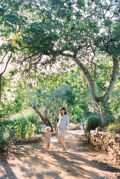 mother and toddler son holding hands on a sunny holiday