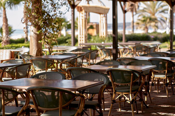 Beach bar, tables and chairs in bright sunny weather with sea view. Summer and vacation concept. High quality photo