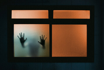 Human hands silhouette behind backlit window