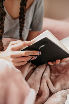 young woman reading her notebook in her bedroom