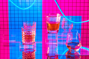 Glasses of champagne on a pink mosaic background with the effect of drawing blue light on a long shutter speed
