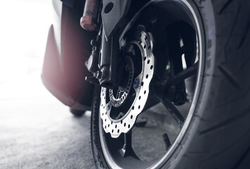 Closeup disc brake of a scooter. Aluminum alloy wheel of motorcycle. Steel rims. Mag wheels of...