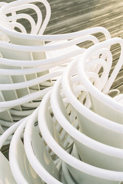 Close up of stacks of white street cafe chairs