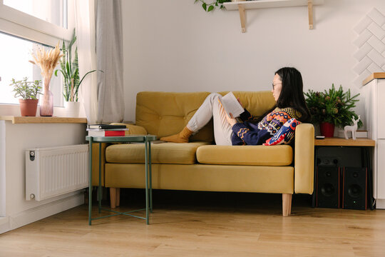 girl reading book on the sofa
