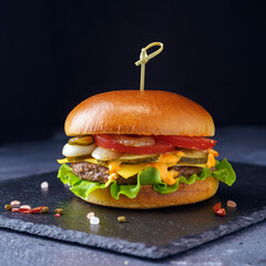 Cheeseburger on a dark stone stand