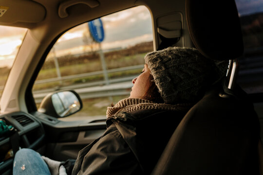 Young woman sleeping on copilot seat in van 