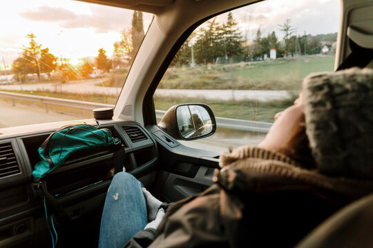 Young woman sleeping on copilot seat in van 