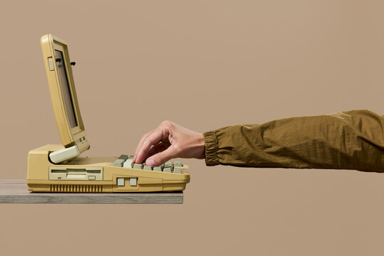 young man using an old laptop computer
